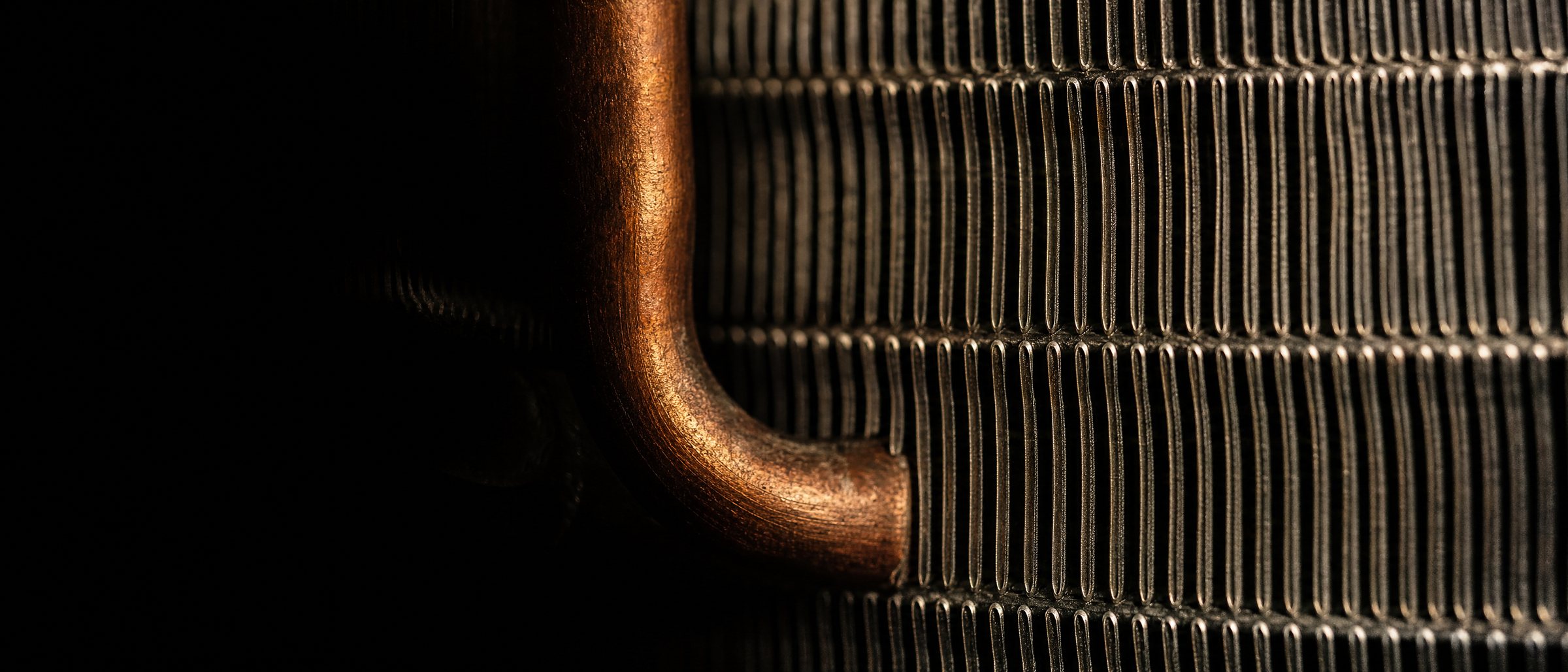 Macro detail of condenser coil fins and copper refrigerant line